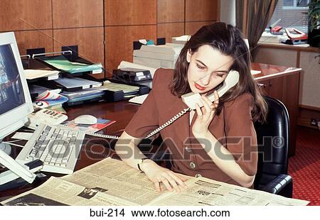 Woman Sitting at Desk Talking on Phone UK View Large Photo Image Picture - Woman Sitting at Desk Talking on Phone UK. Fotosearch