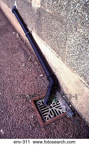 Stock Image - Black Domestic Waste Pipe Leading to Drain. Fotosearch