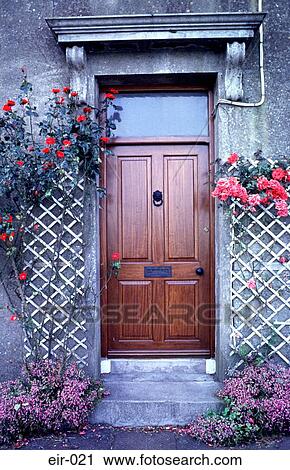 Stock Image - Entrance with Brown Door and Flowers. Fotosearch