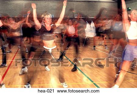 Stock Image - Front View of Aerobics Class with Motion Blur. Fotosearch