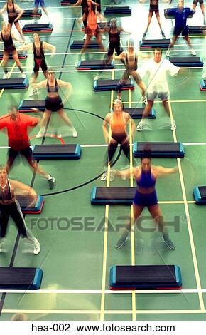 Stock Image - Front View of People at a Step Aerobics Class. Fotosearch