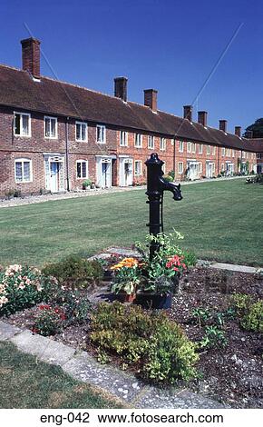 Stock Image - Old Water Pump outside Cloistered Houses England UK. Fotosearch