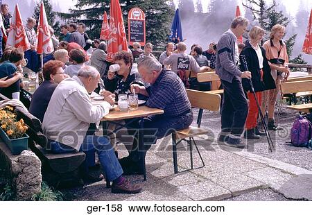 Stock Photo - People Drinking Outside Bar Bavarian Alps Germany. Fotosearch