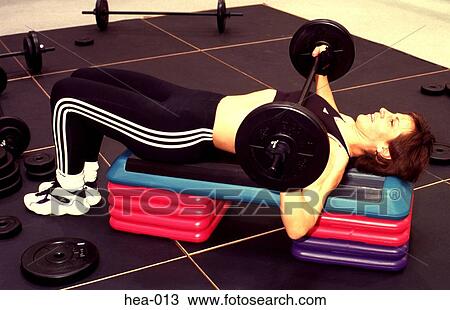 Stock Image - Side View of Woman doing Bench Presses. Fotosearch