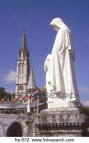 Stock Image - Statue and Basilica Lourdes France. Fotosearch