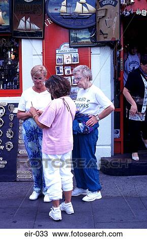 Stock Image - Three Ladies Outside Antique Shop Dublin. Fotosearch