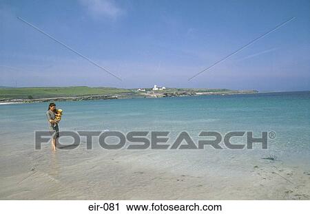 Woman Holding Baby Paddling in the Sea at Inishmore View Large Photo Image Stock Image - Woman Holding Baby Paddling in the Sea at Inishmore. Fotosearch