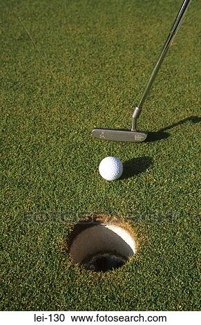 Stock Image - Close Up of Golf Ball Being Putted at Short Range. Fotosearch