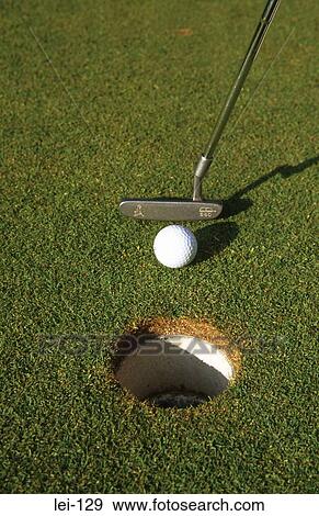 Stock Photo - Close Up of Golf Ball Being Putted at Short Range. Fotosearch