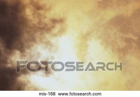 Stock Photo - Cloudy Sky with Partial Eclipse. Fotosearch