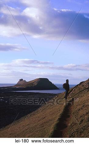 Hiker with Worms Head in Background Gower Wales UK View Large Photo Image Stock Image - Hiker with Worms Head in Background Gower Wales UK. Fotosearch