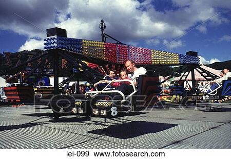 Man and Children on Spinning Wheel at Fairground View Large Photo Image Stock Photo - Man and Children on Spinning Wheel at Fairground. Fotosearch