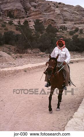 Stock Image - Man on Horseback in Arabic Dress Jordan. Fotosearch