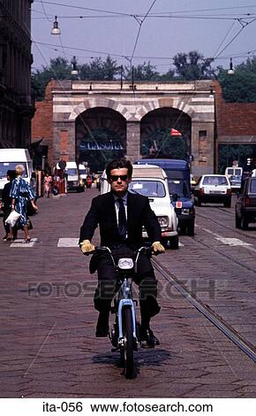 Stock Photograph - Man on Moped on Road in Milan Italy Europe. Fotosearch