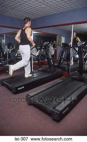 Man on Running Machine UK View Large Photo Image Stock Photo - Man on Running Machine UK. Fotosearch