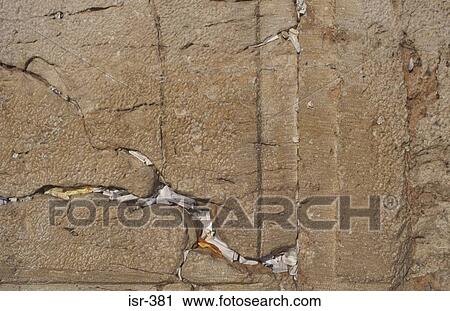 Stock Image - Prayers in Cracks of Wailing Wall Jerusalem. Fotosearch