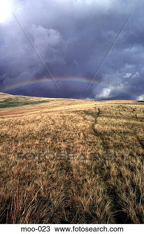 Stock Image - Rainbow and Storm Clouds over Welsh Hills. Fotosearch