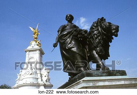Stock Image - Statue of Man & Lion Queen Victoria Memorial London. Fotosearch