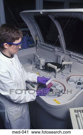 Stock Image - Technician Operating Automated Reagent Equipment UK. Fotosearch