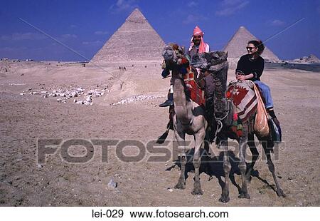Tourist Girl on a Camel in Front of Pyramids Egypt View Large Photo Image Stock Photo - Tourist Girl on a Camel in Front of Pyramids Egypt. Fotosearch