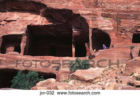 Stock Image - Two Tourists Exploring Cisterns Petra Jordan. Fotosearch