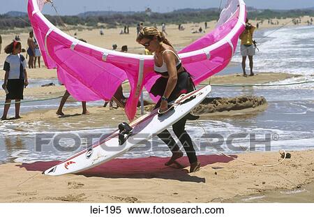 Stock Photography - Woman Carrying Windsurfing Equipment. Fotosearch