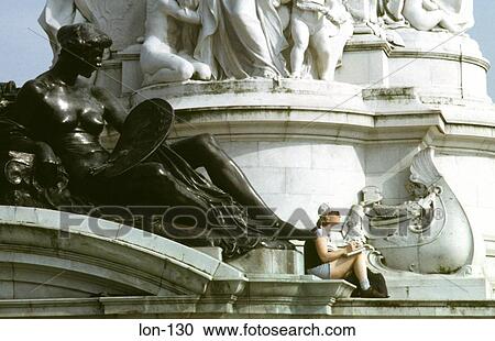 Stock Image - Woman Sitting on Queen Victoria Memorial London UK. Fotosearch