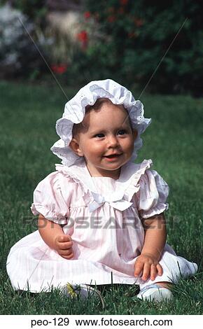 Stock Photo - Baby Girl Sitting in Grass on a Summers Day. Fotosearch