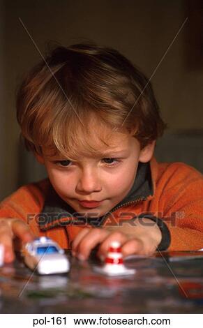 Stock Image - Boy Playing with Model Police Car. Fotosearch