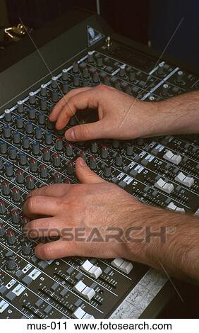 Stock Image - Hands at Mixing Desk in Studio. Fotosearch