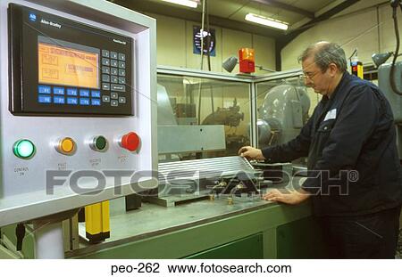 Stock Image - Man at Computer Controlled Lathe. Fotosearch