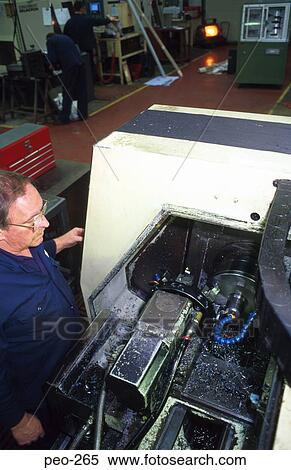 Stock Photography - Man at Computer Controlled Lathe. Fotosearch