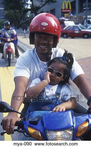 Man Smiling with Child on Motor bicycle Kuala Lumpur Malaysia View Large Photo Image Stock Image - Man Smiling with Child on Motor bicycle Kuala Lumpur Malaysia. Fotosearch