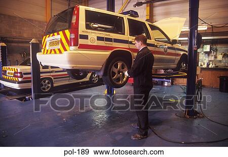 Stock Photo - Police Patrol Car on Inspection Lift UK. Fotosearch