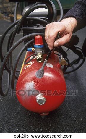 Stock Photography - Policeman Dusting Compressor Receiver for Fingerprints UK. Fotosearch