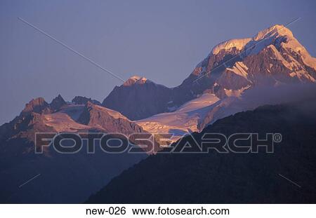 Stock Photograph - Snow Capped Peaks Caught in Sun New Zealand. Fotosearch