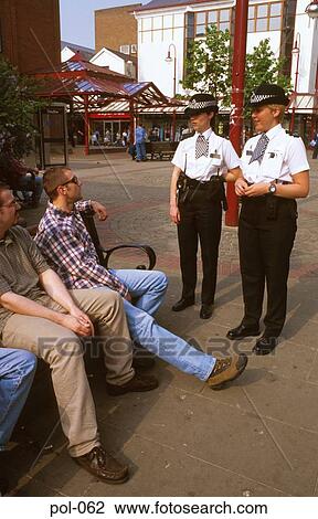 Stock Image - Two Policewomen Talking to Youths. Fotosearch
