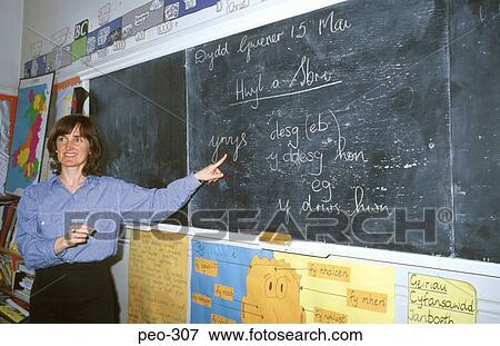 Stock Photo - Welsh Language Teacher Pointing at Blackboard. Fotosearch