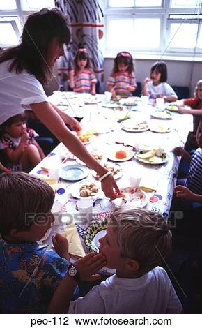 Stock Image - Woman Serving at Children's Party UK. Fotosearch