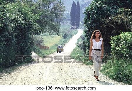 Stock Photograph - Woman Walking along Country Lane. Fotosearch