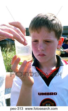 Stock Image - Young Boy Looking at Pond Life in Jar Wales. Fotosearch