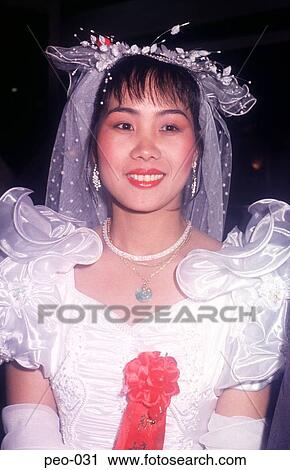 Stock Image - Young Chinese Woman Smiling wearing Wedding Dress. Fotosearch
