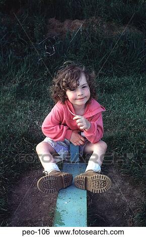 Stock Photograph - Young Girl Playing on See-Saw in Park UK. Fotosearch