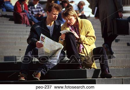 Stock Photo - Young Tourist Couple on Steps Looking at Map London. Fotosearch