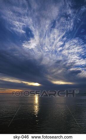 Stock Photograph - Cirrocumulus Clouds at Sunset over Sea. Fotosearch