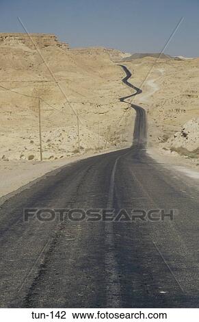 Stock Image - Desert Road Winding into the Hills Metlaoui Tunisia. Fotosearch