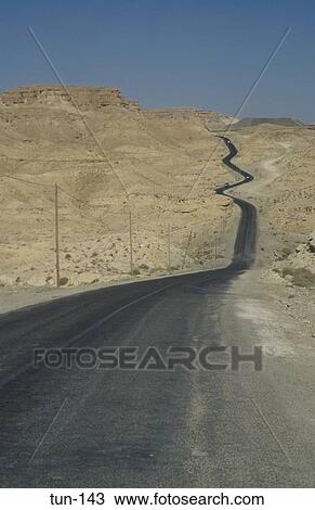 Stock Image - Desert Road Winding into the Hills Metlaoui Tunisia. Fotosearch