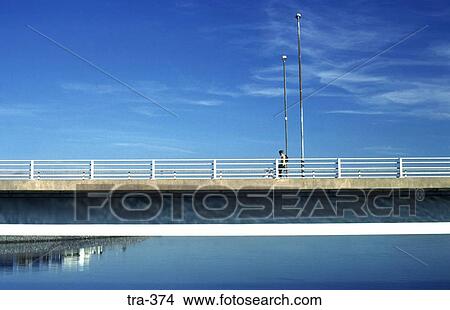 Picture - Lone Cyclist on Concrete Road Bridge. Fotosearch