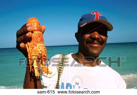 Stock Photography - Man Selling Crawfish on Isla Grande Beach Colombia. Fotosearch