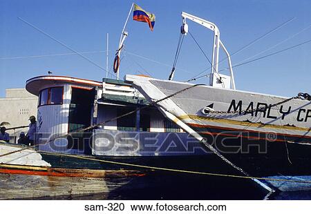 Stock Image - Wooden Boat Flying Colombian Flag. Fotosearch